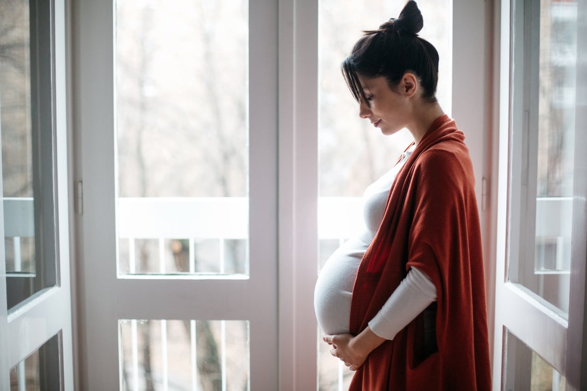 Pregnant Woman Standing on a Balcony